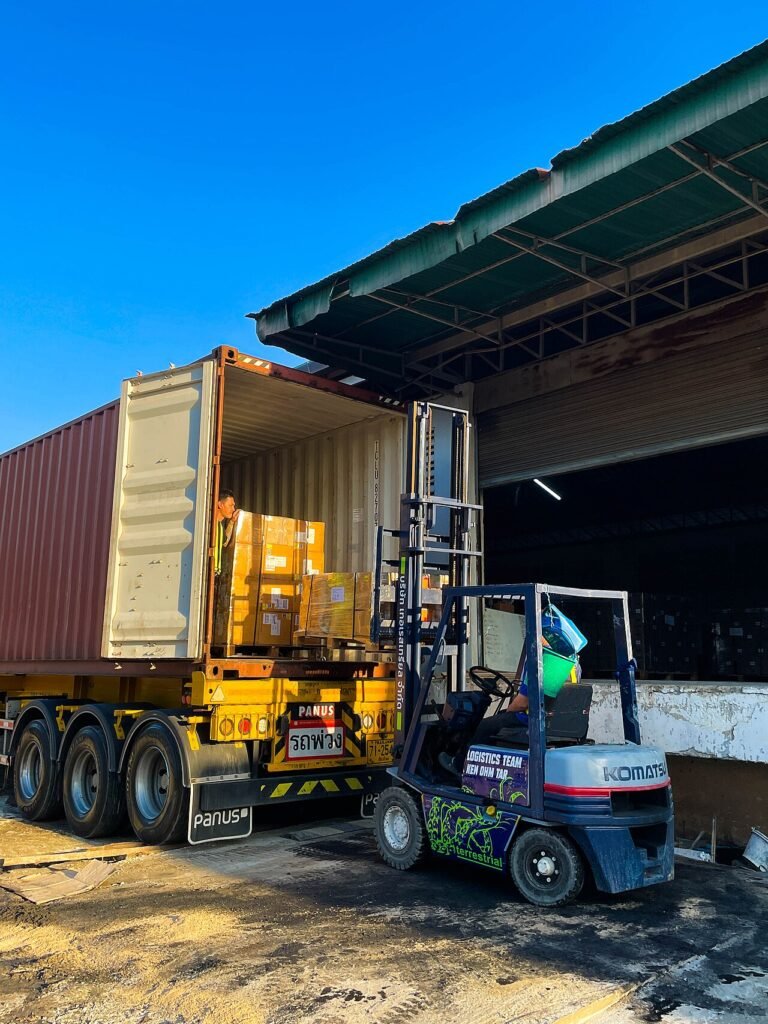 Container being loaded by forklift at a warehouse dock
