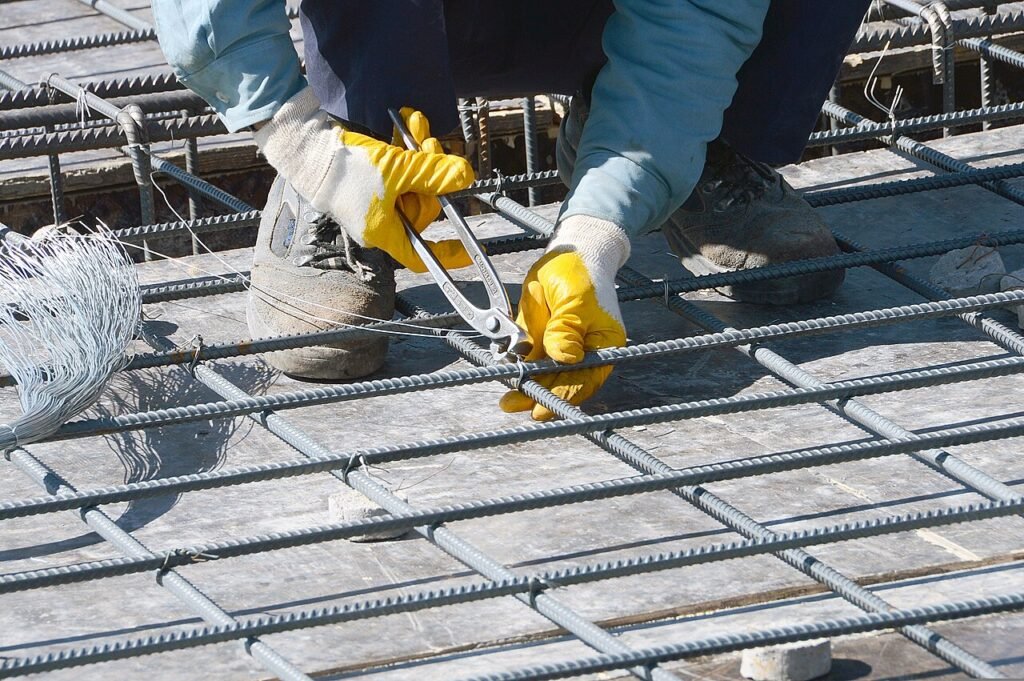 Steel fixer tying reinforcing bar on a construction site