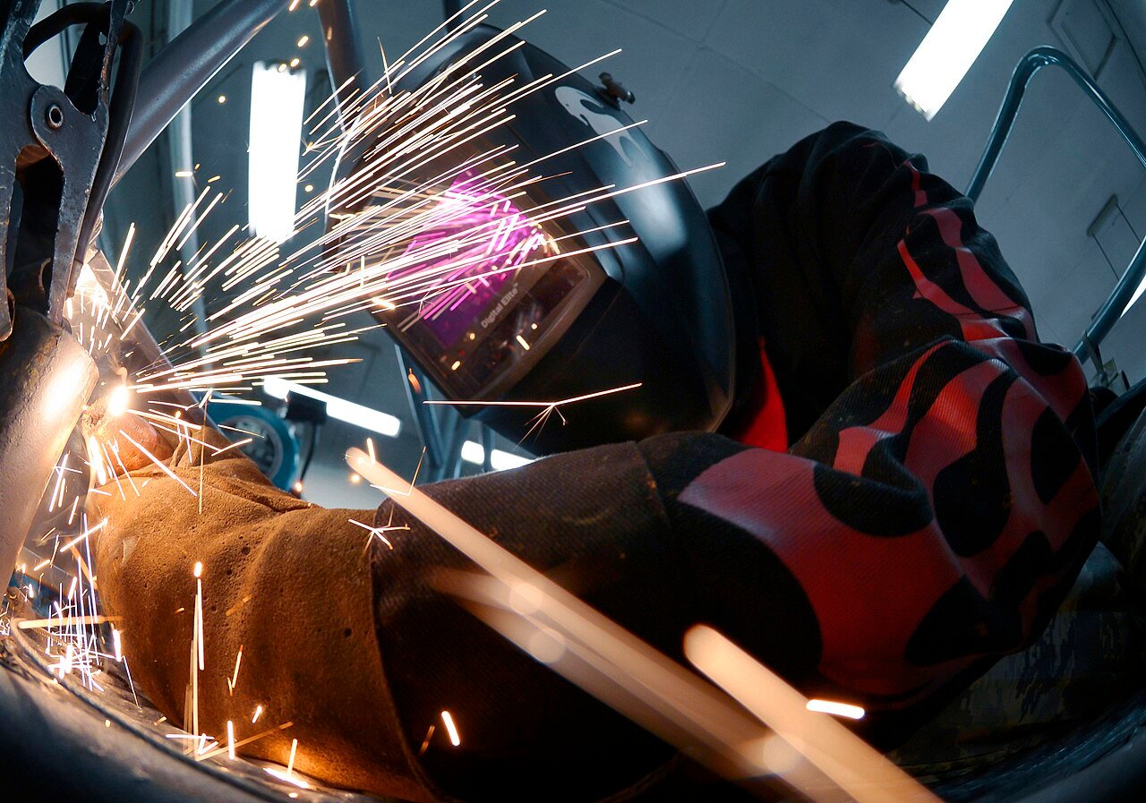 Welder working with sparks flying in metal fabrication